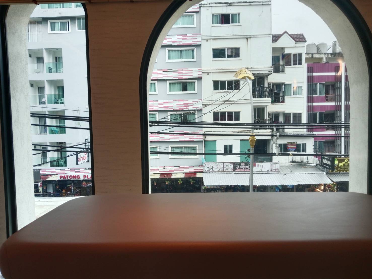 Heat and UV film on an arched balcony window overlooking Patong condos