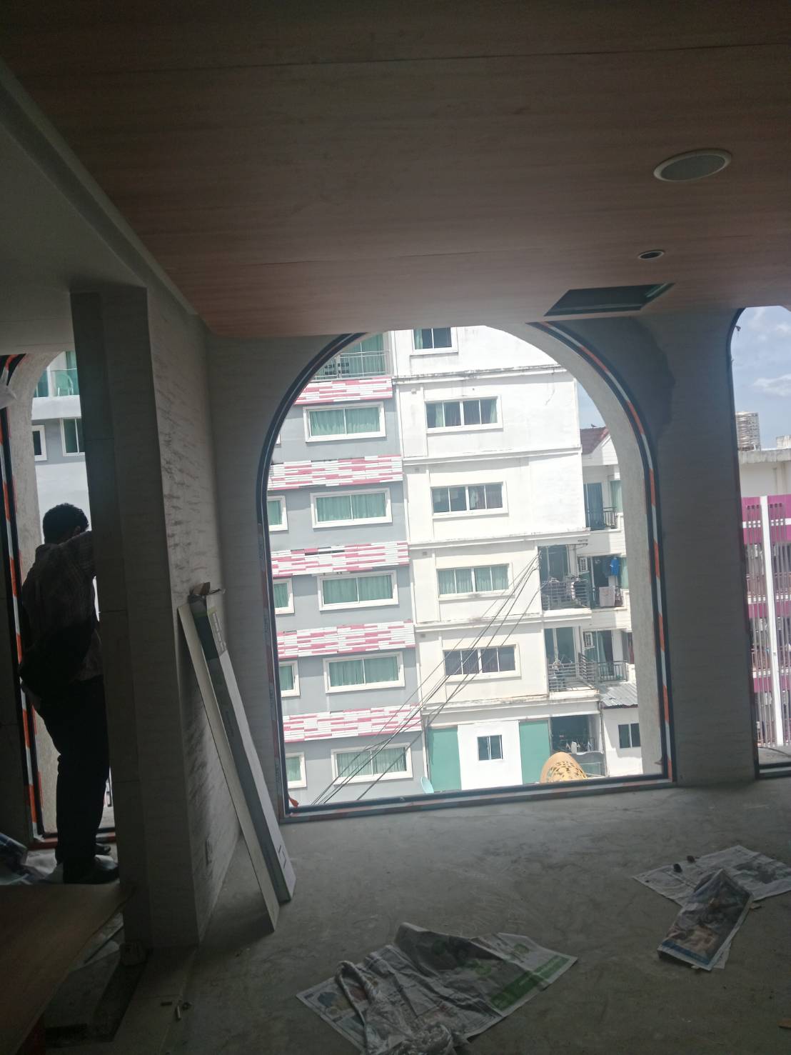 JaiDeeClear technician installing heat and UV film on a full-height arched high-rise condo window at The Cube Amaze, Patong