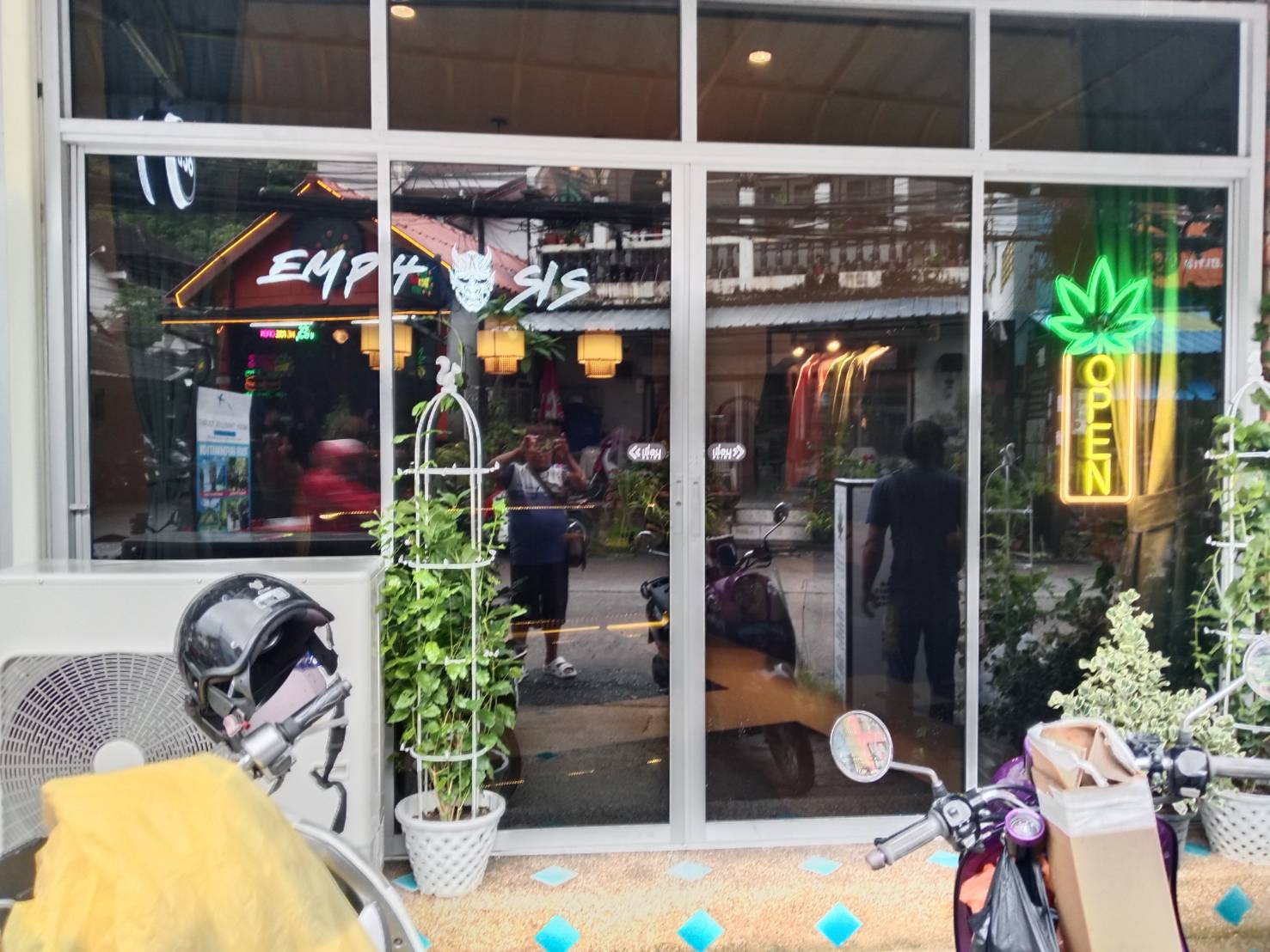 JaiDeeClear window film on a street-level shophouse frontage in Patong, Phuket — full-height glass with scooters parked outside